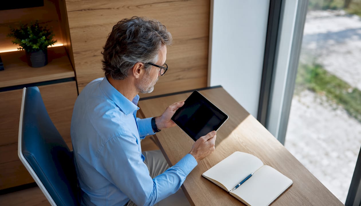 Arzt im Profil mit Tablet in moderner Praxisumgebung