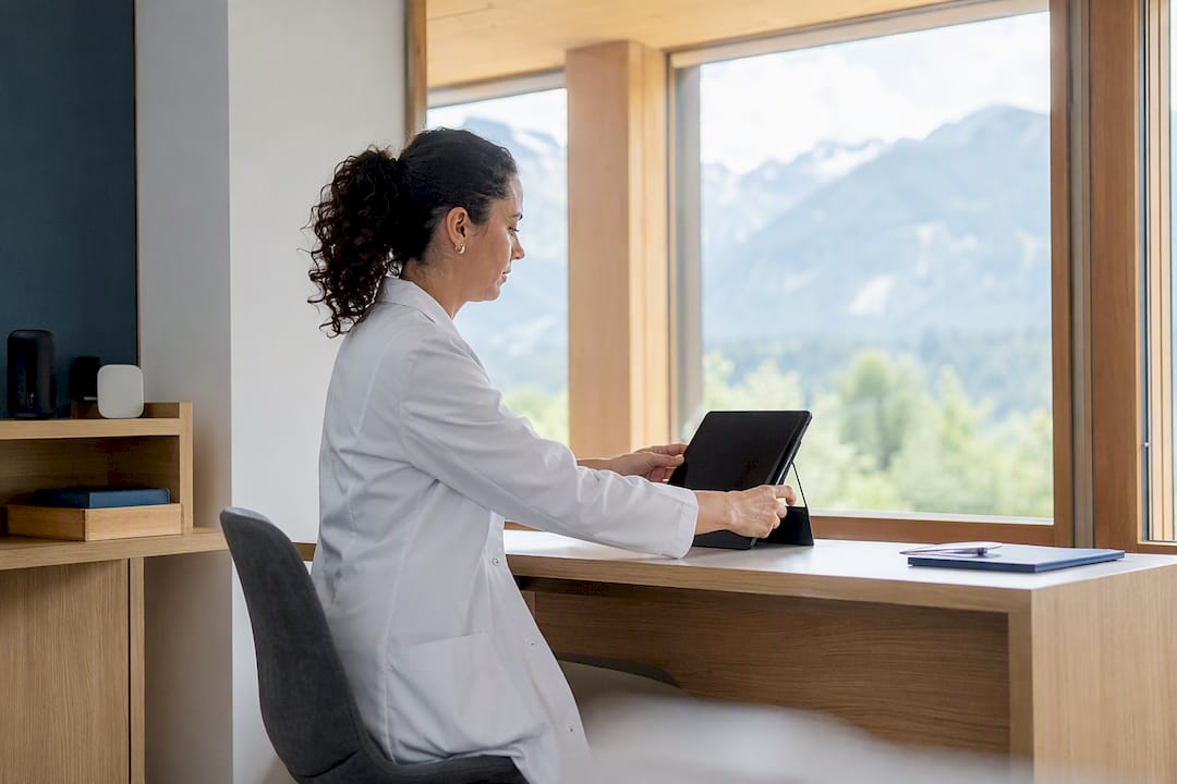 Eine medizinische Fachkraft nutzt ein Tablet im Therapieraum.